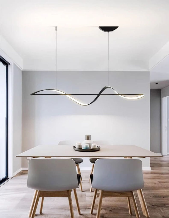 Lustre suspendu noir au design minimaliste illuminant une table de salle à manger moderne.