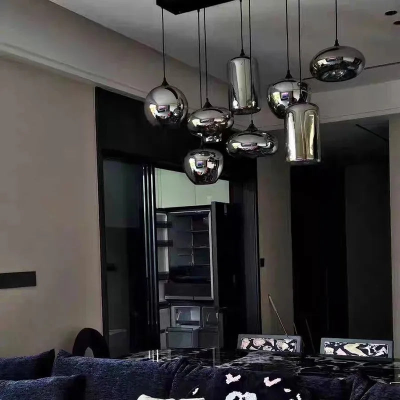 Lustre suspension multi-lampes en verre fumé illuminant un salon au style design et épuré.