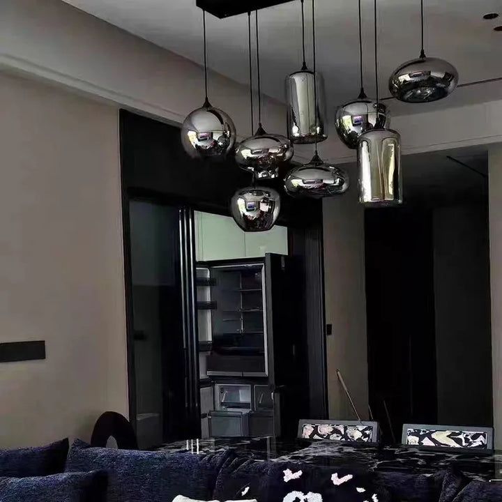 Lustre suspension multi-lampes en verre fumé illuminant un salon au style design et épuré.