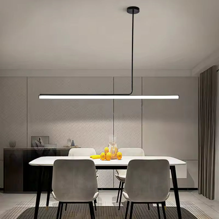 Élancé au-dessus de la table, ce lustre tube LED avec structure en métal noir renforce l’allure épurée et moderne de la salle à manger.