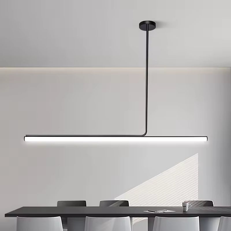 Ligne lumineuse très épurée pour ce lustre tube noir LED, installé au-dessus d’une table dans un décor contemporain.