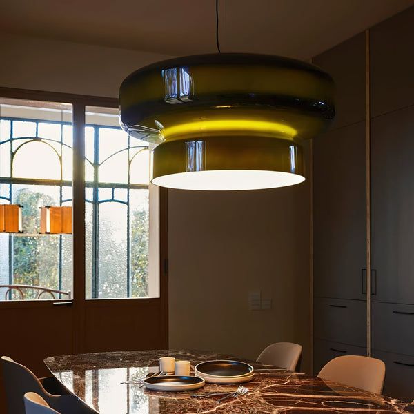 Lustre contemporain en verre fumé vert illuminant une table de salle à manger chic et sombre