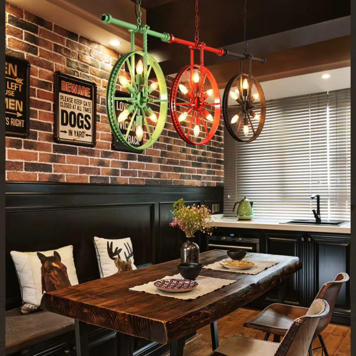 Trois lustres roue colorés à 6 lumières au-dessus d’une table en bois, dans une salle à manger industrielle et rétro