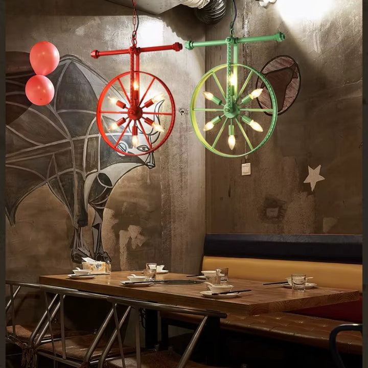 Deux lustres roue rouge et vert à 6 lumières dans un intérieur brut, inspiré des ateliers et du style industriel vintage