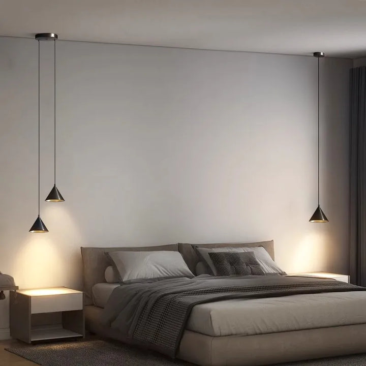 Paire de suspensions design installées de chaque côté d'un lit double, apportant une touche chic et symétrique.