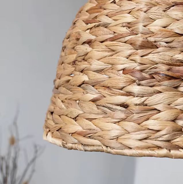 Gros plan sur le tressage artisanal d'une petite suspension en rotin au style naturel et esprit maison de campagne