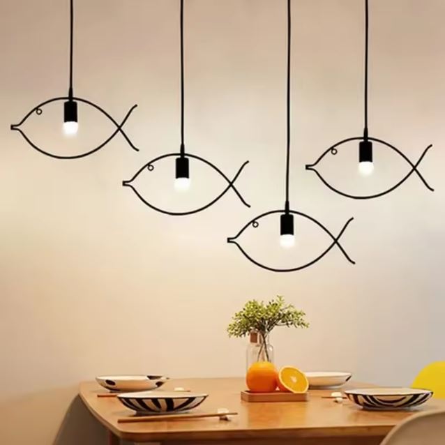 Quatre suspensions poisson en métal noir, parfaites pour une décoration moderne et un éclairage élégant dans une salle à manger.
