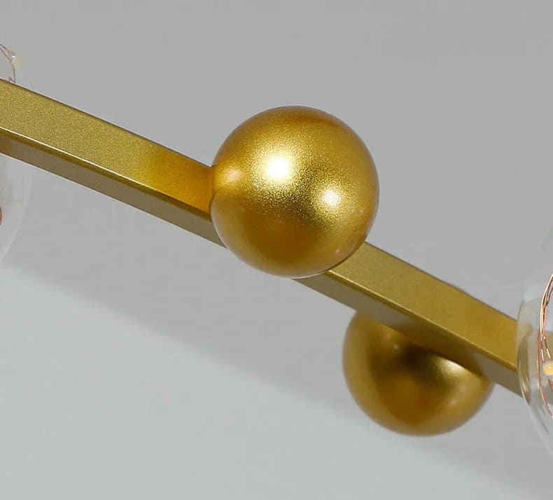 Élément de raccord doré ornant la structure épurée de la suspension lumineuse contemporaine