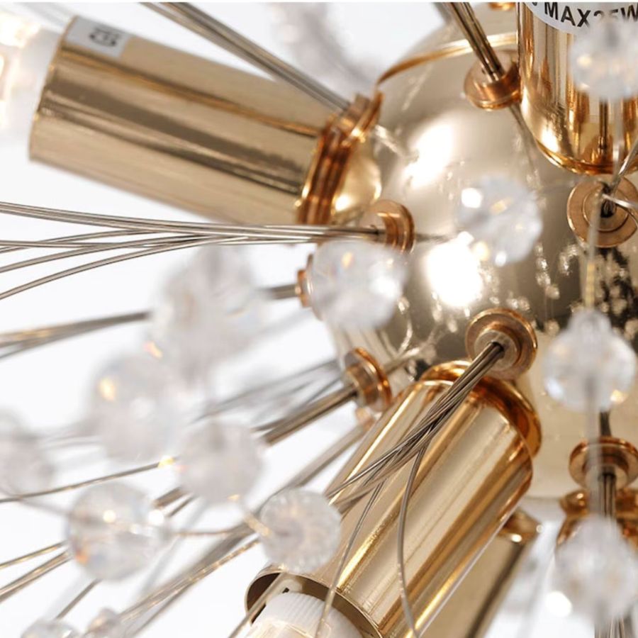 Détail de la structure dorée rayonnante et des perles transparentes d’un lustre pissenlit sculptural