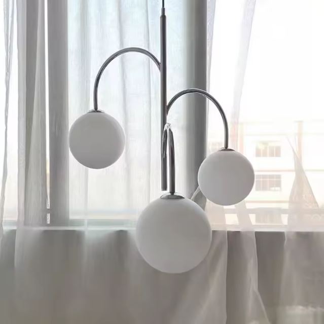 Suspension 3 globes en verre chrome avec trois sphères blanches, un design moderne et élégant, pour un éclairage raffiné.