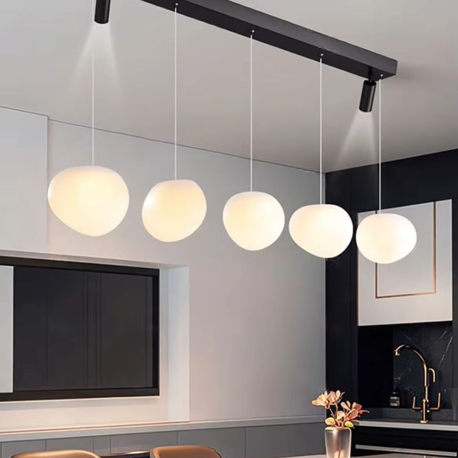Alignement élégant de cinq globes opalins sur une suspension linéaire noire au style moderne et minimaliste