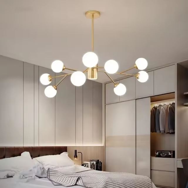 Suspension 9 globes en verre et métal doré installée dans une chambre moderne, parfaite pour une ambiance lumineuse et élégante.