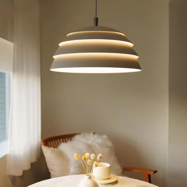 Suspension abat jour blanc esprit japandi moderne, luminaire aux courbes superposées diffusant une lumière douce.