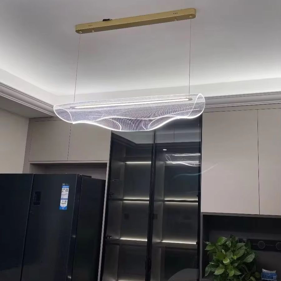 Suspension LED en acrylique transparent aux ondulations sculpturales, installée dans une cuisine moderne et élégante