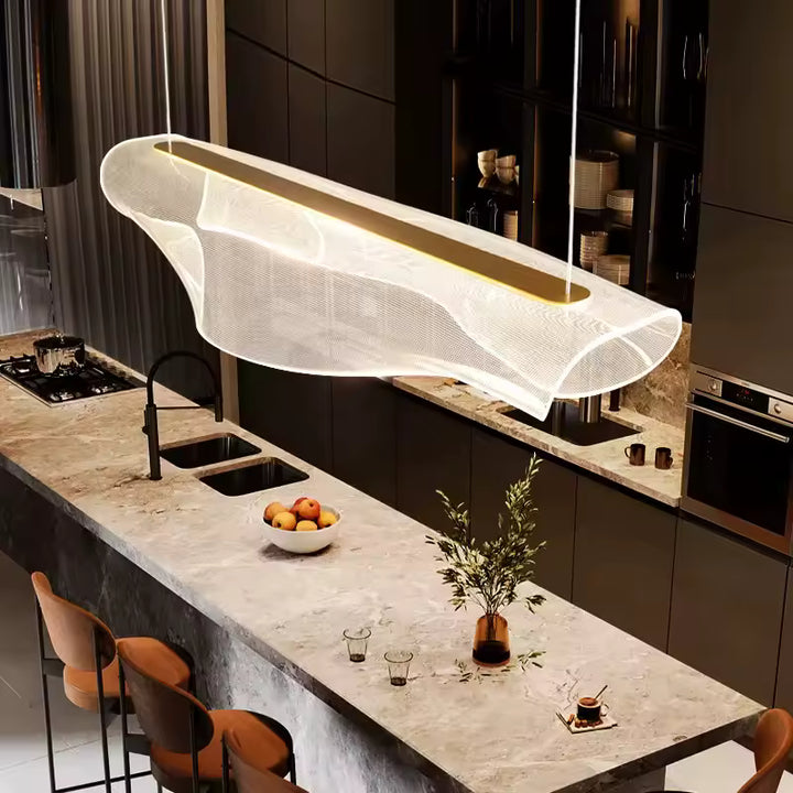 Suspension sculpturale en acrylique aux courbes fluides et contemporaines, installée au-dessus d’un îlot de cuisine