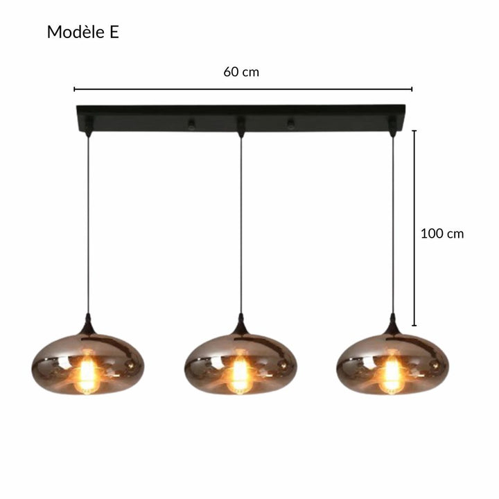 Suspension alignée de trois abat-jours sphériques en verre fumé sur barre noire.