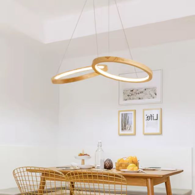 Suspension anneau bois en double cercle, idéale pour une salle à manger lumineuse au design épuré et mobilier en bois clair.