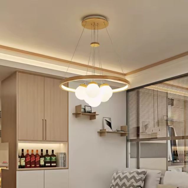 Suspension bois avec anneau lumineux et globes blancs, parfaite pour une ambiance scandinave, moderne et chaleureuse dans le salon.