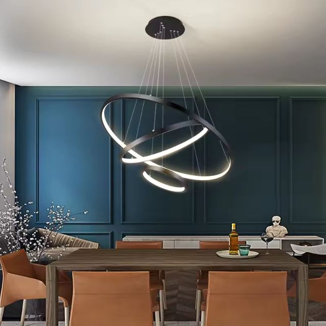 Suspension anneau LED noire créant une ambiance lumineuse et moderne au-dessus d'une salle à manger élégante.
