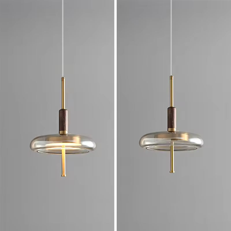 Suspension en anneau de verre avec tige dorée, silhouette minimaliste présentée allumée et éteinte