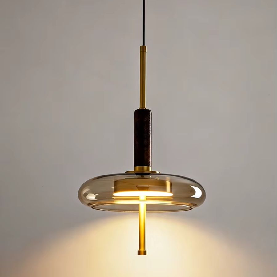 Suspension design à anneau de verre, tige dorée et bois foncé diffusant une lumière chaude contemporaine
