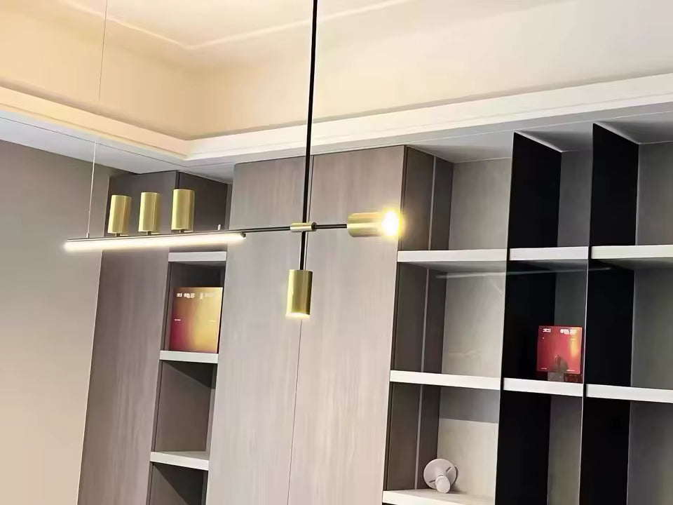 Suspension asymétrique noire et dorée au design graphique avec éclairage LED intégré et détails cylindriques raffinés