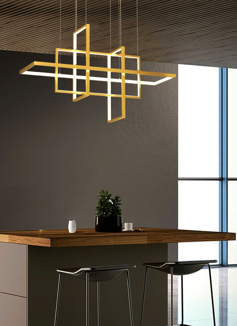 Suspension lumineuse dorée à cadres architecturaux suspendue au-dessus d'un comptoir de bar.