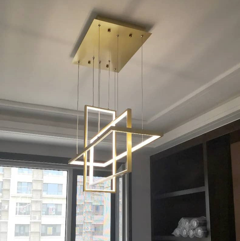Vue en plongée d'un luminaire suspendu doré à structure géométrique sophistiquée et moderne.