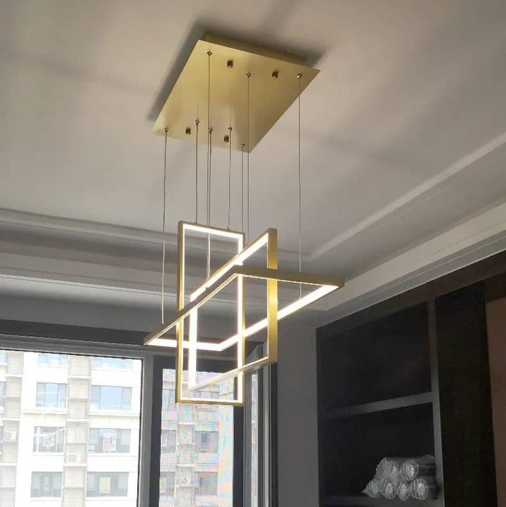 Vue en plongée d'un luminaire suspendu doré à structure géométrique sophistiquée et moderne.