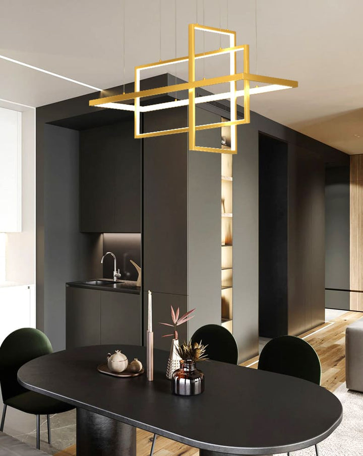 Suspension dorée à cadres entrecroisés éclairant une table à manger dans un décor moderne.