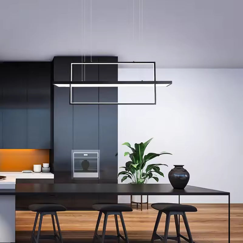 Suspension à barre LED et cadre noir rectangulaire, au style architectural épuré au-dessus d'un îlot de cuisine.