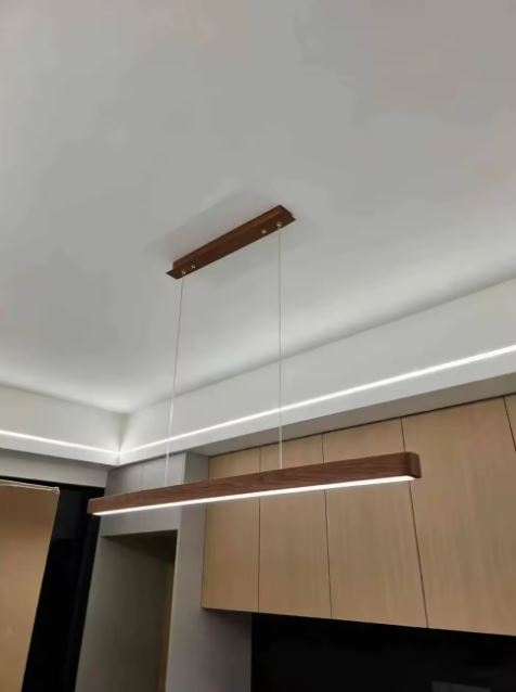 Suspension barre en bois foncé avec LED intégrée, luminaire japandi contemporain parfait pour une cuisine épurée et moderne.