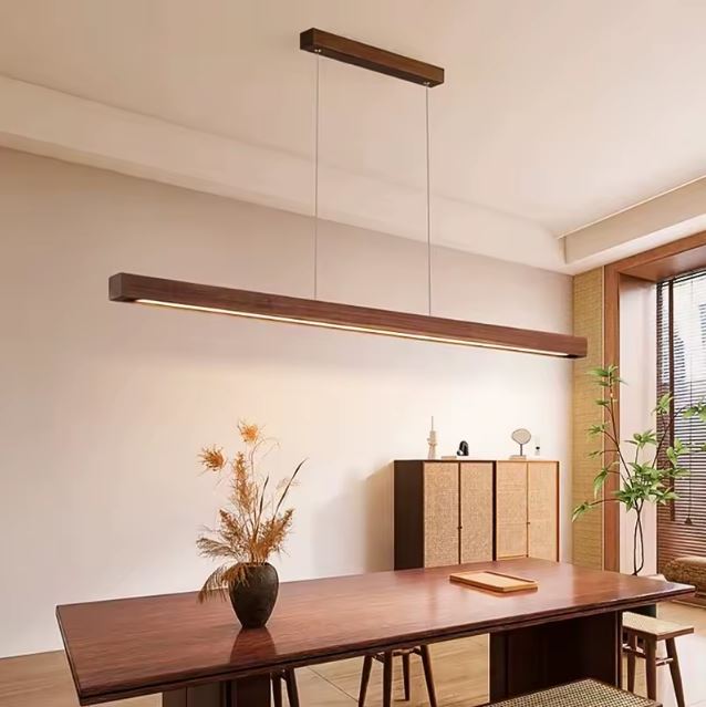 Suspension barre en bois foncé avec LED intégrée, luminaire minimaliste contemporain idéal pour une grande table à manger.