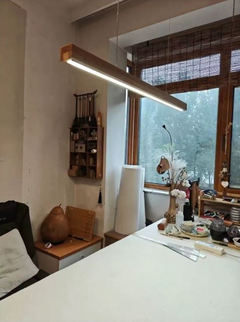 Suspension barre en bois avec LED intégrée, luminaire scandinave contemporain offrant un éclairage linéaire élégant pour bureau.