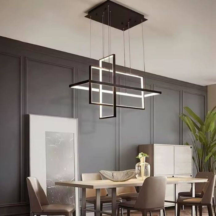 Suspension LED noire à cadres entrecroisés, au design structuré et contemporain au-dessus d'une table de salle à manger.