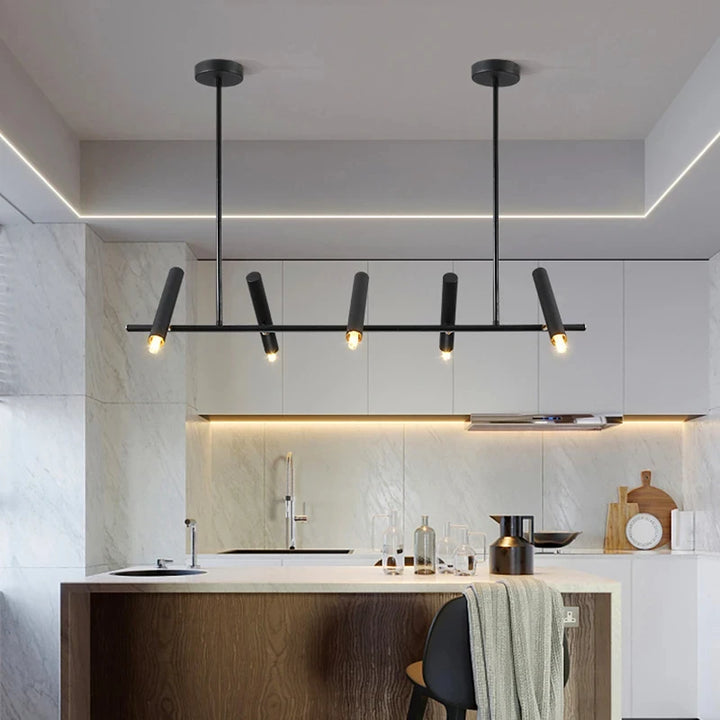 Suspension design à cylindres LED orientés suspendue au-dessus d'un îlot de cuisine.