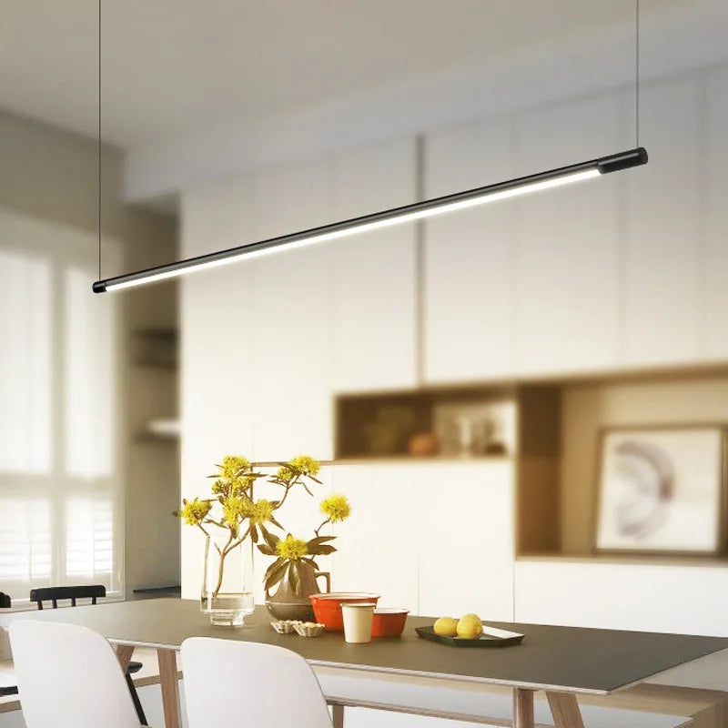 Suspension barre LED ultra fine au design moderne illuminant une table à manger épurée.