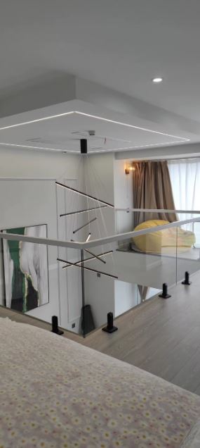 Suspension à barres LED noires en cascade, luminaire au design géométrique contemporain idéal pour une cage d’escalier moderne.
