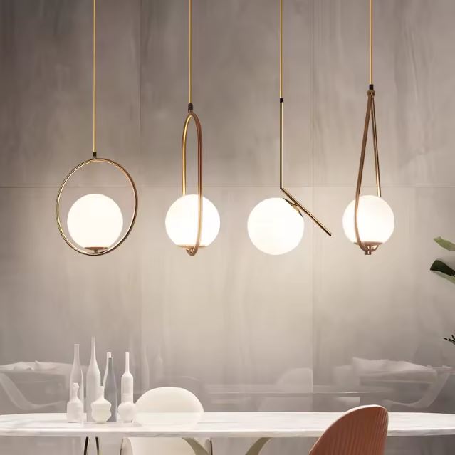 Suspension blanche et dorée au design moderne, parfaite pour illuminer une salle à manger avec élégance.