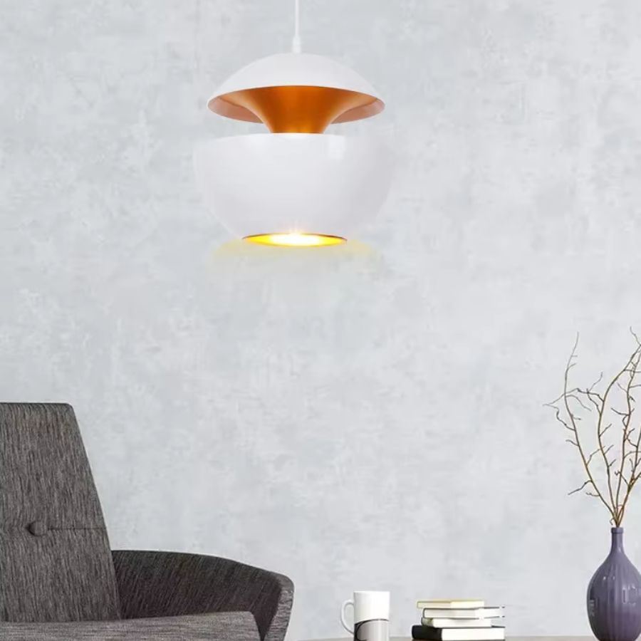 Dans un salon épuré, suspension blanche à double coque métallique avec intérieur cuivré au style minimaliste