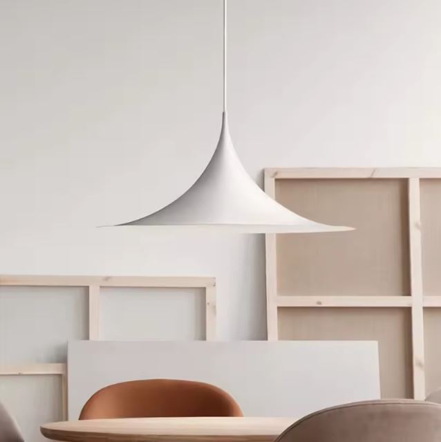 Suspension blanche effilée au-dessus d’une table, avec une allure scandinave, japandi et résolument moderne.