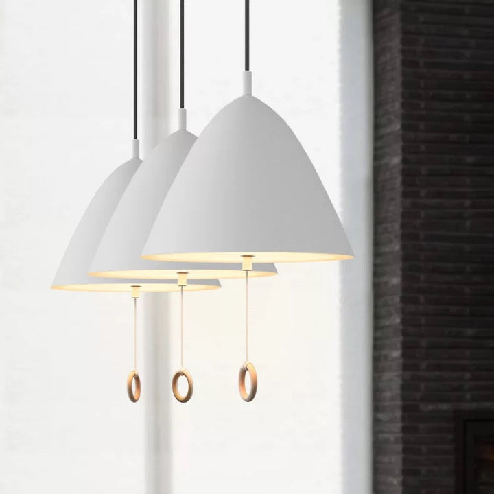 Suspension LED blanche avec tirette dans un intérieur contemporain et soigné.