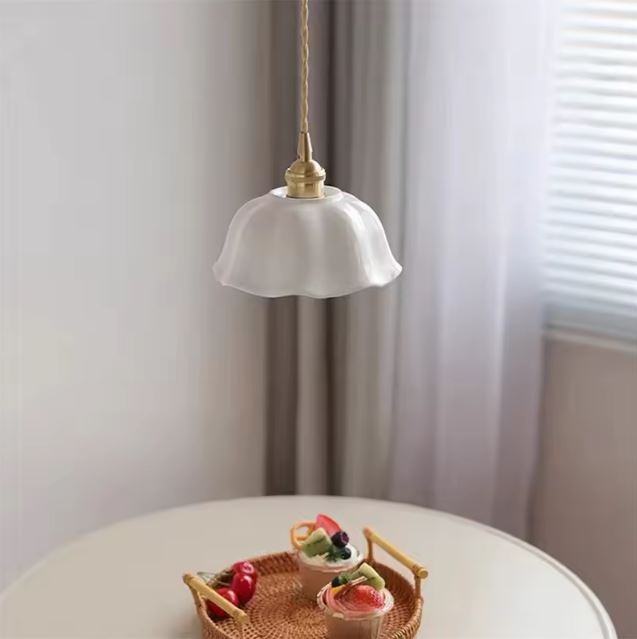 Suspension blanche en porcelaine en forme de fleur, parfaite au-dessus d’une table pour une ambiance naturelle et douce à vivre.