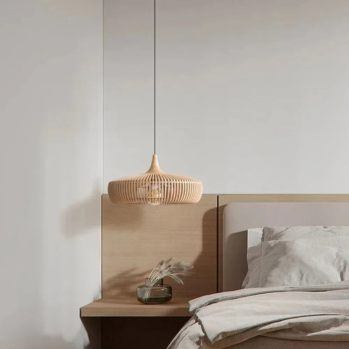 Lampe suspendue en bois naturel installée dans une chambre chaleureuse et apaisante.