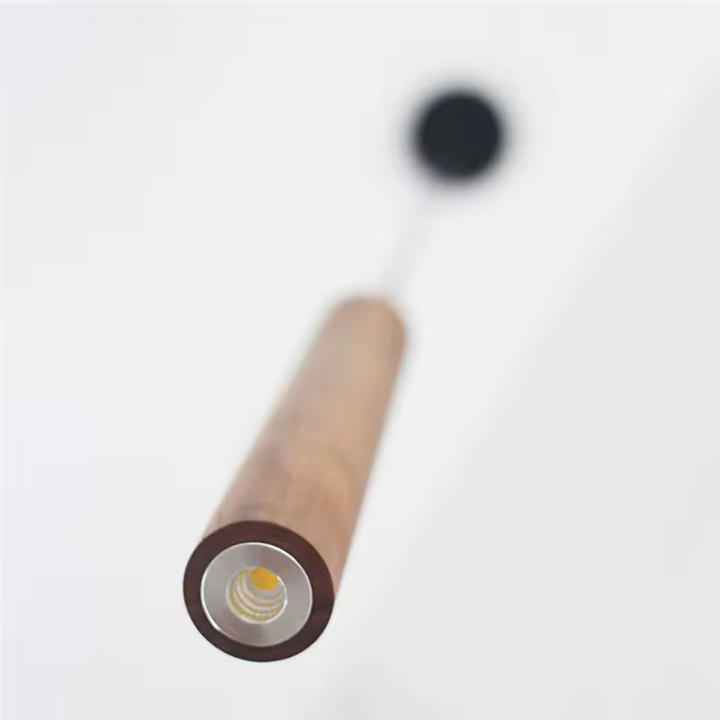 Vue rapprochée d’une suspension en bois cylindrique au style épuré avec éclairage LED intégré