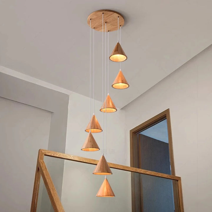 Suspension sculpturale en bois à plusieurs cônes lumineux, idéale pour décorer une cage d'escalier moderne.