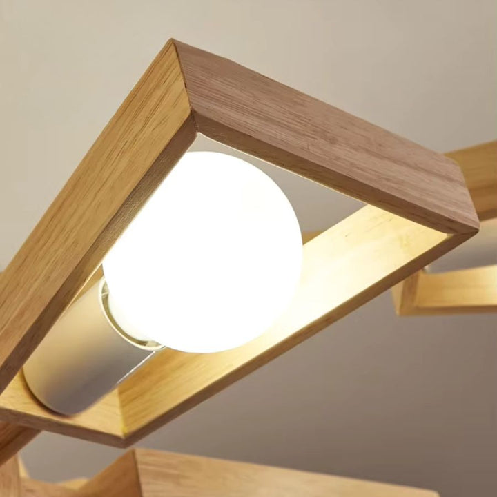 Gros plan sur le globe lumineux opalin encadré de bois d’une suspension au design géométrique et chaleureux