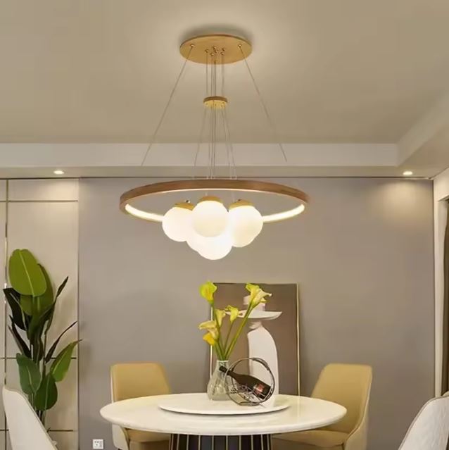 Suspension en bois avec globes en verre blanc, au design moderne et chaleureux, idéale au-dessus d'une table ronde de salle à manger.