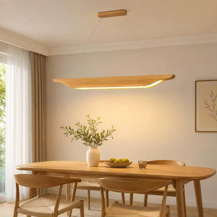 Au-dessus d'une table en bois, suspension linéaire aux courbes naturelles et LED chaude dans une salle à manger japandi.