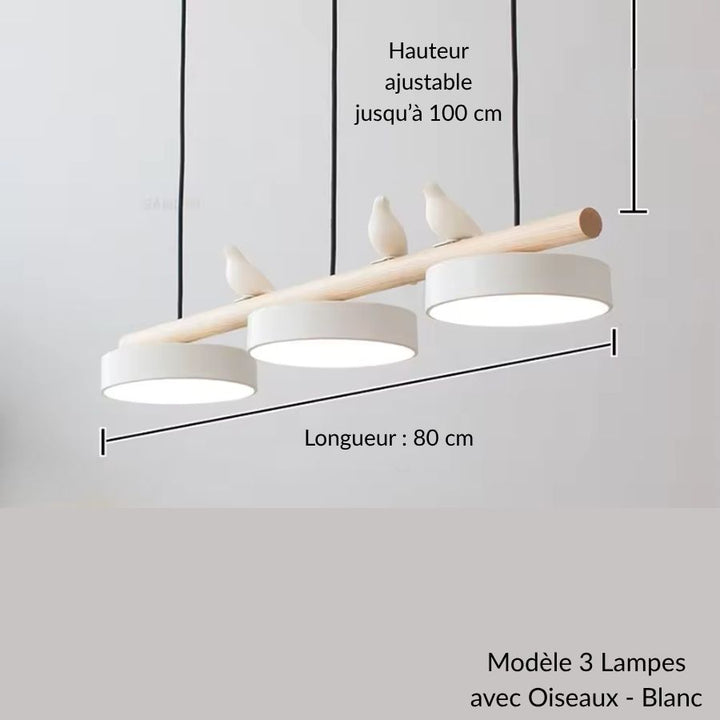 Tout en douceur, trois disques blancs et des oiseaux sculptés habillent cette suspension en bois d’esprit scandinave